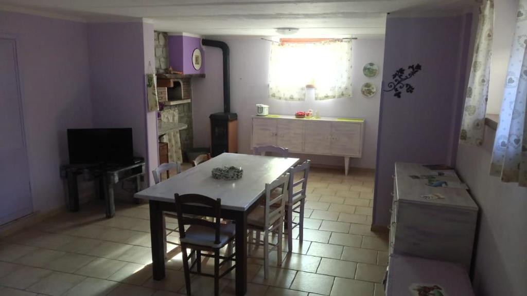 una cucina e una sala da pranzo con tavolo e sedie di B&b La Violetta a SantʼAnna Pelago