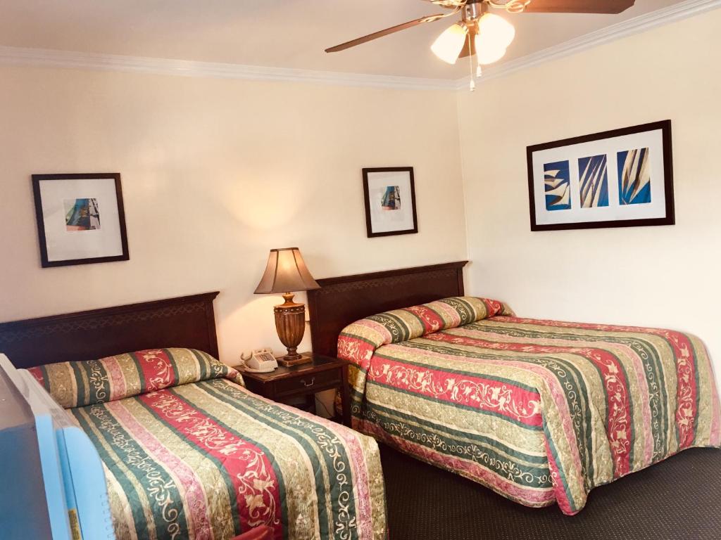 a hotel room with two beds and a ceiling fan at Los Feliz Hotel in Glendale