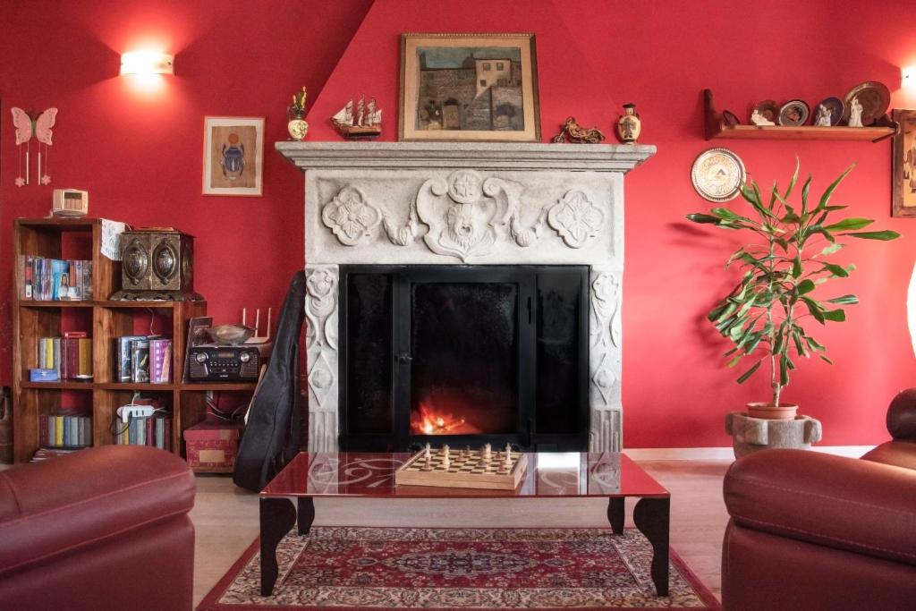 sala de estar con chimenea y paredes rojas en Villa Farfalla Bianca, en Vitorchiano