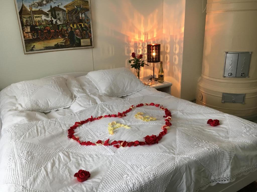 a heart made out of roses on a bed at Villa Korkatti in Haapavesi