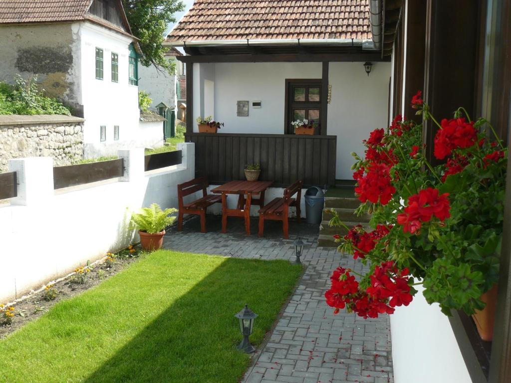 - un petit jardin avec une table et des fleurs rouges dans l'établissement Casa Demeter, à Rimetea