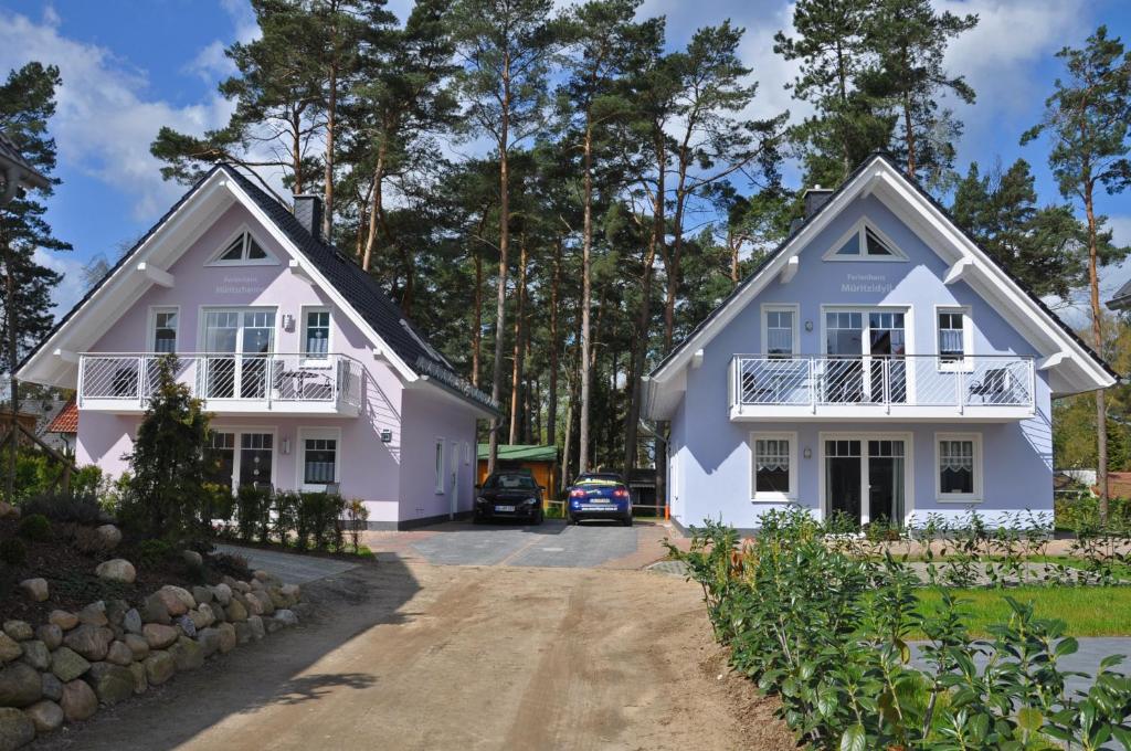 une maison avec deux maisons blanches dans l'établissement Ferienhaus Müritzidyll / EG-Appartement, à Marienfelde