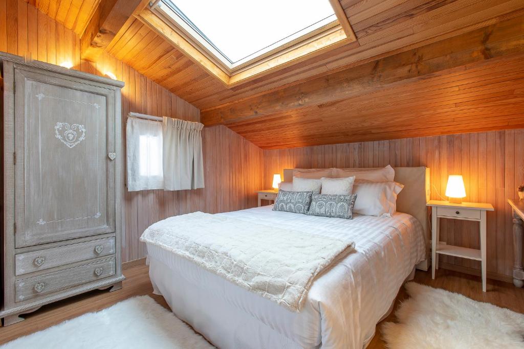 sypialnia z dużym łóżkiem i oknem dachowym w obiekcie Le Catarina w mieście Lathuile