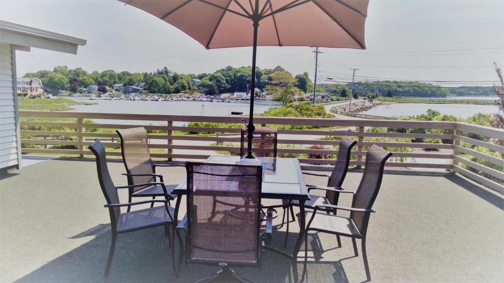 a table and chairs with an umbrella on a porch at Caster Holdings in Mystic
