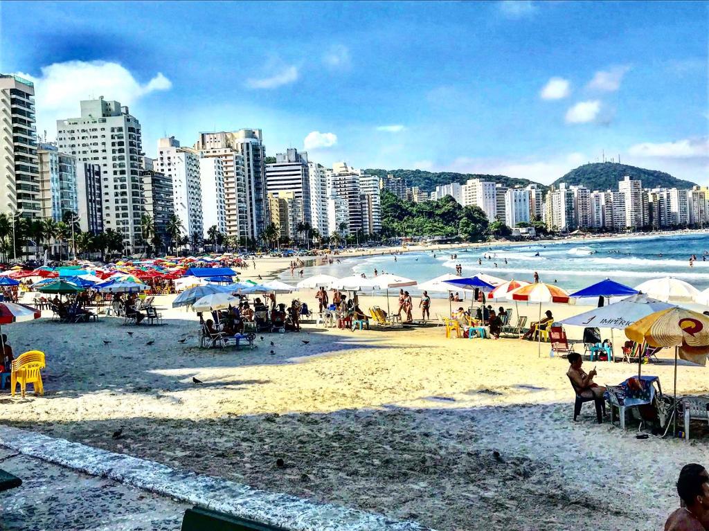 una spiaggia con ombrelloni e persone sulla sabbia di Ibiza a Guarujá
