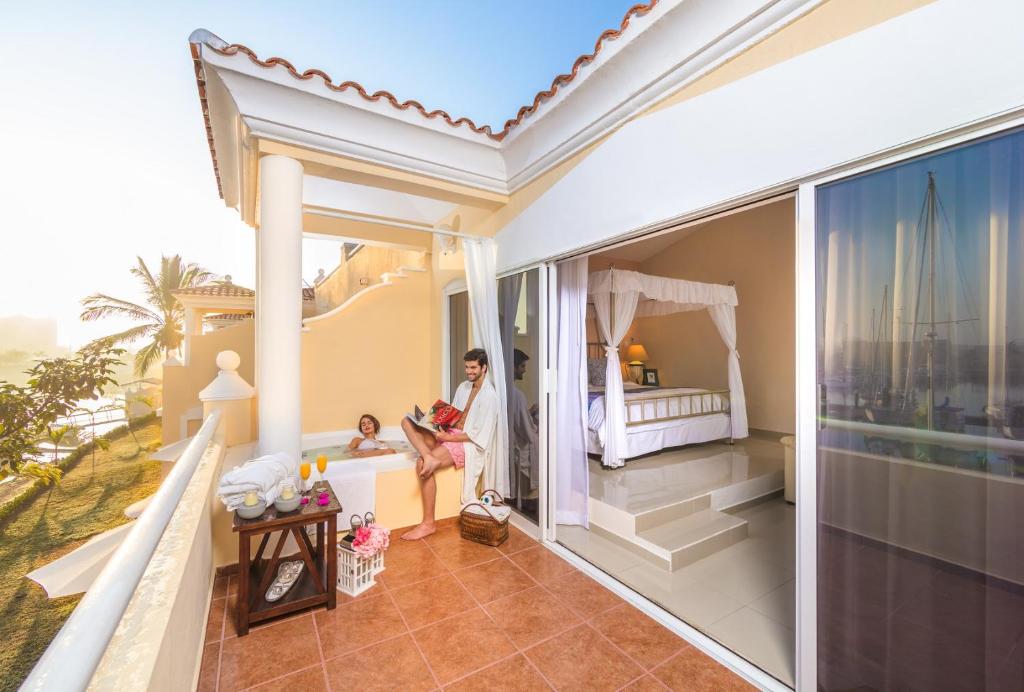 a woman and a child standing in a house with a bedroom at Isla Mazatlan Residence Club in Mazatlán
