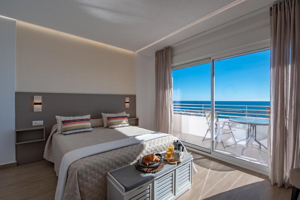 Schlafzimmer mit einem Bett und einem großen Fenster mit Meerblick in der Unterkunft Alicante Skylights Apartments in Alicante