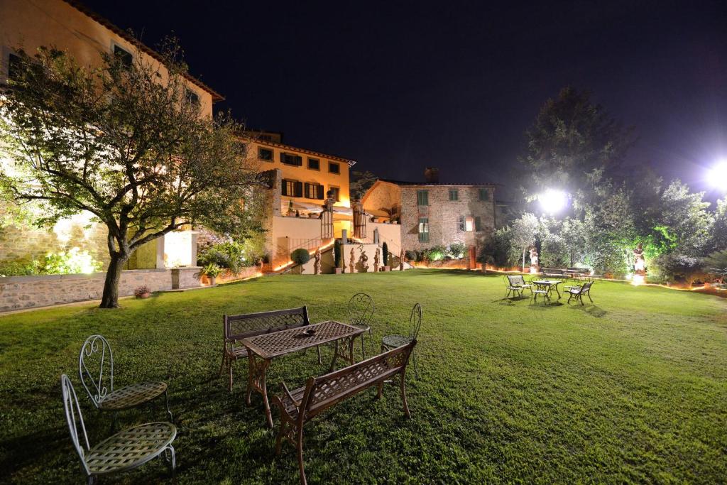 a group of tables and chairs in a field at night at Anacleto in Collodi