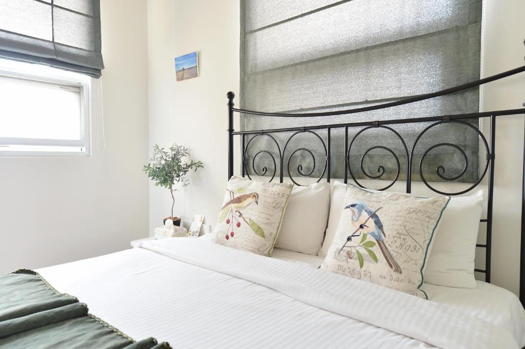 a bedroom with a bed with white sheets and pillows at Penghu Chenhi Bay Homestay in Baisha