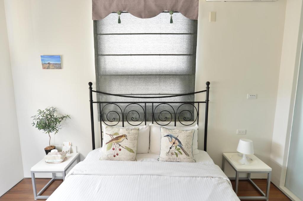 a bedroom with a bed with a black headboard at Penghu Chenhi Bay Homestay in Baisha