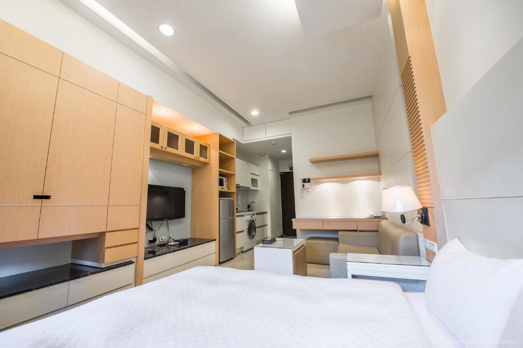 a bedroom with a white bed and a kitchen at 謙匯國際酒店式公寓 CH Service Apartment in Taipei