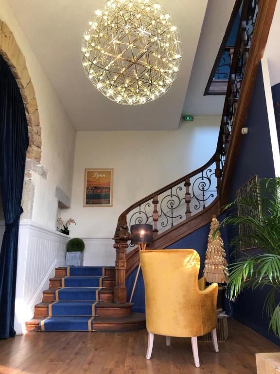 a living room with a staircase with a chandelier at Hotelo Lyon Charité in Lyon