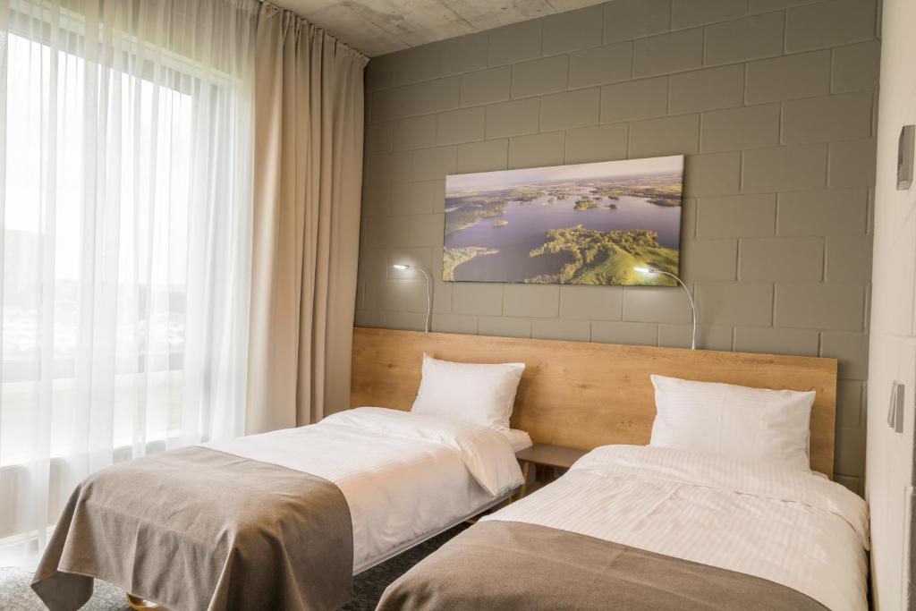 a bedroom with two beds and a window at Air Hotel in Karmėlava