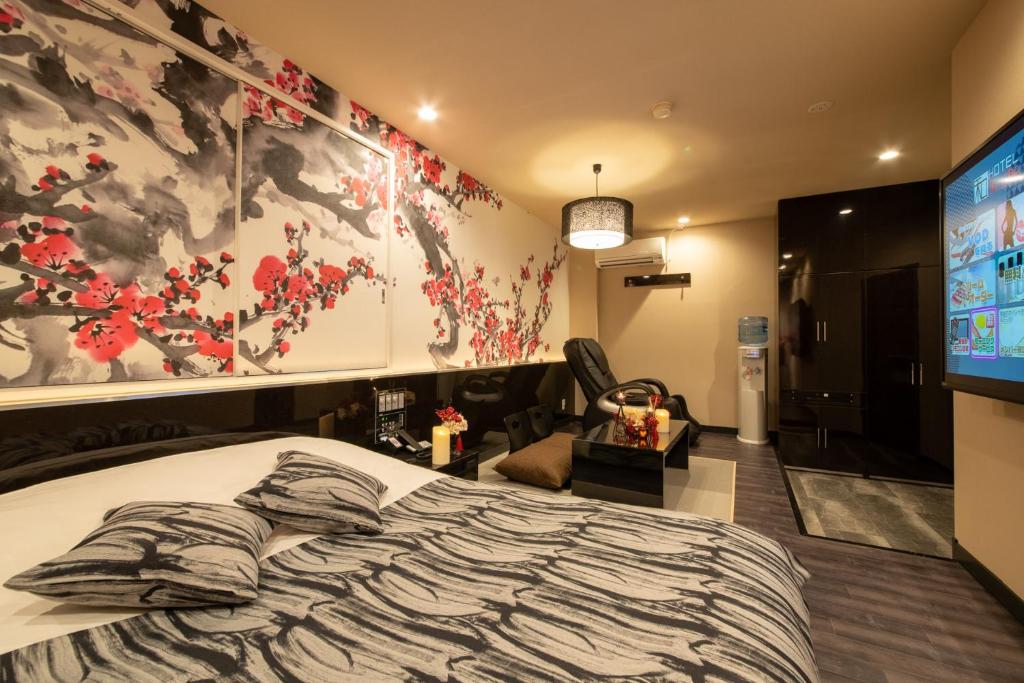 Hotel Waraku Shibukawa في Shibukawa: غرفة نوم بسرير كبير وتلفزيون