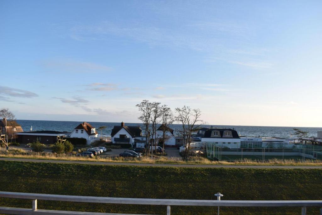 a group of houses and the ocean with a fence at Haus am Deich Wohnung 12 in Dahme