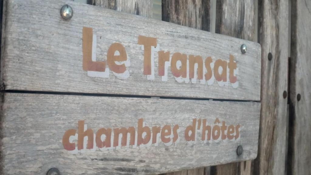 a wooden sign on a wooden wall with the words lac internet chambers ofhots at LE TRANSAT in Ambatoloaka