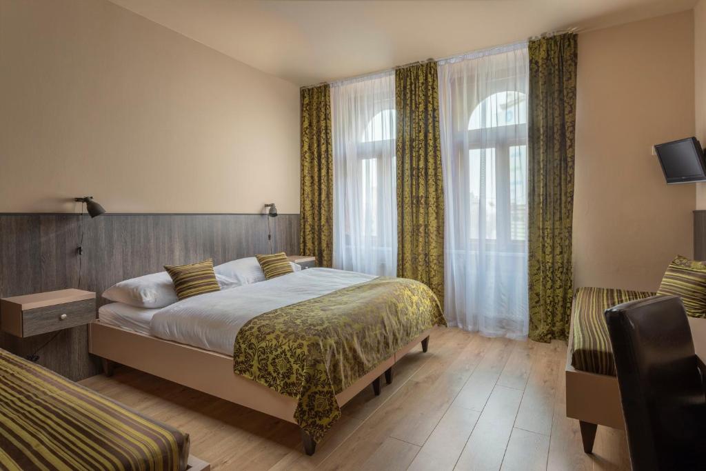 a hotel room with a bed and two chairs at Hotel Superior Prague in Prague