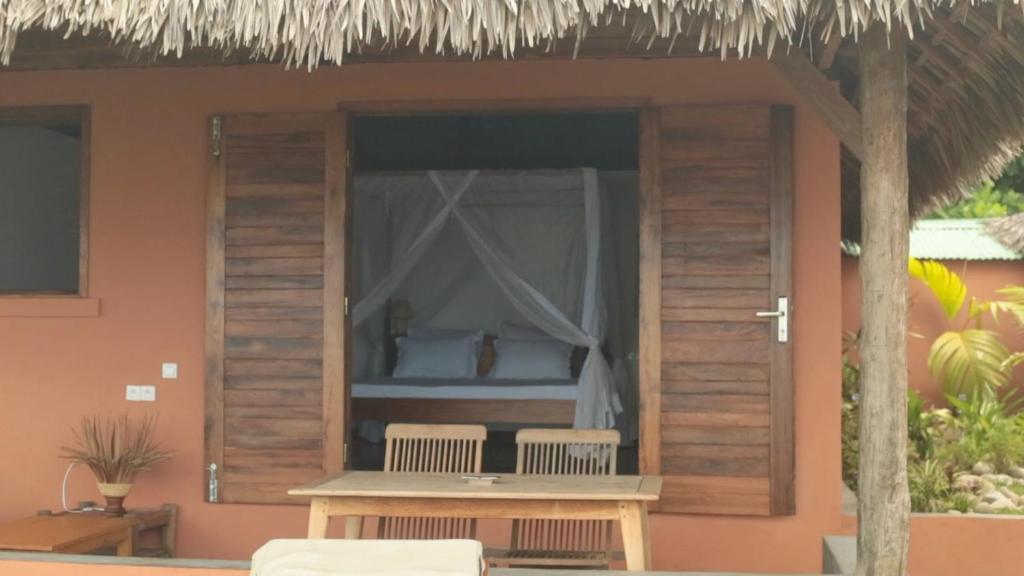 a bed in a window of a house at LE TRANSAT in Ambatoloaka