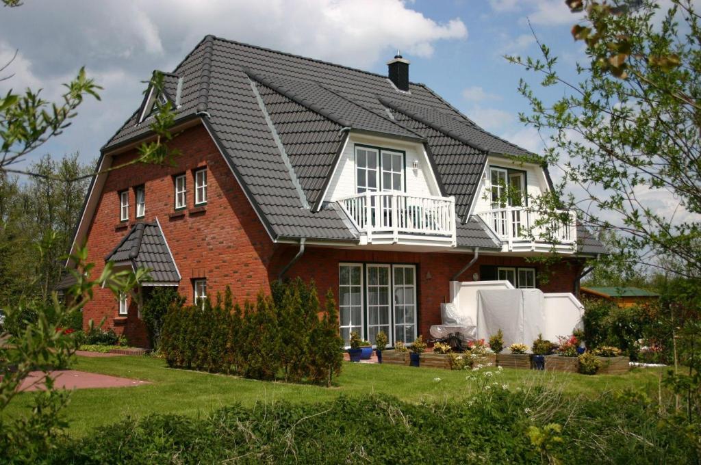 una casa de ladrillo rojo con techo negro en Gaestehaeuser-Heidehof-Wohnung-1 en Süderhöft