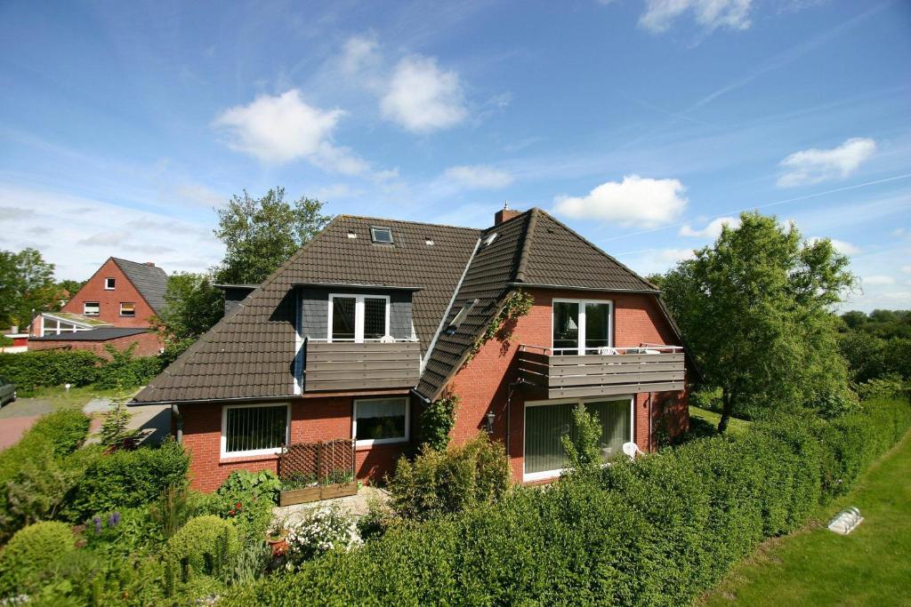 a red house with a black roof at Gaestehaeuser-Heidehof-Wohnung-3 in Süderhöft