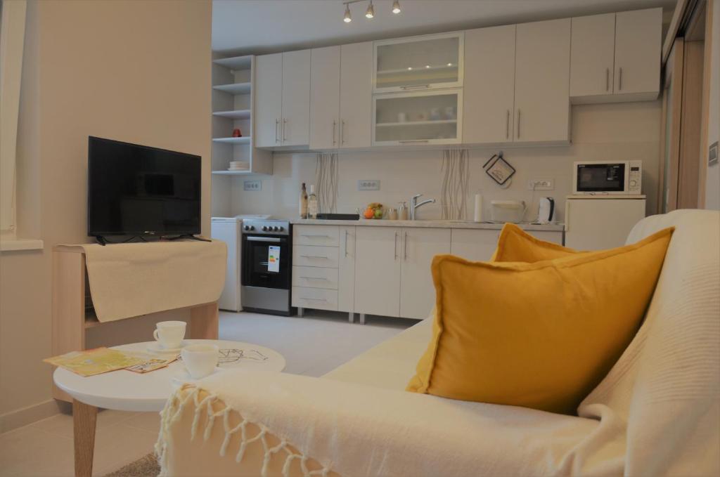 un soggiorno con divano bianco e tavolo di Spacious 2-bedroom apartment with luxury feel a Novi Sad