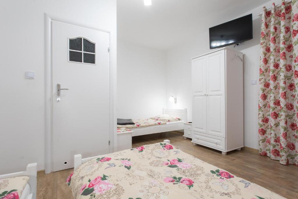 um quarto branco com uma cama e um berço em Willa Parkowa em Rymanów-Zdrój