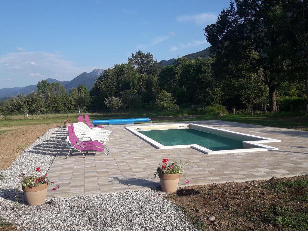 un patio con piscina, una silla y flores en Bungalows Rizvan City, en Brušane