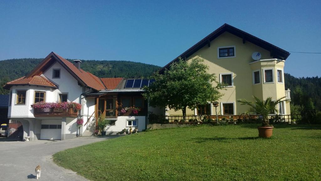 Una gran casa amarilla con paneles solares. en Ferienwohnung Schlögelhofer en Lunz am See