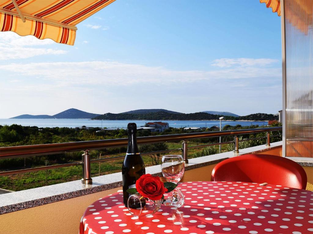 un tavolo con una bottiglia di vino e un bicchiere di Iva Apartmani a Tribunj (Trebocconi)