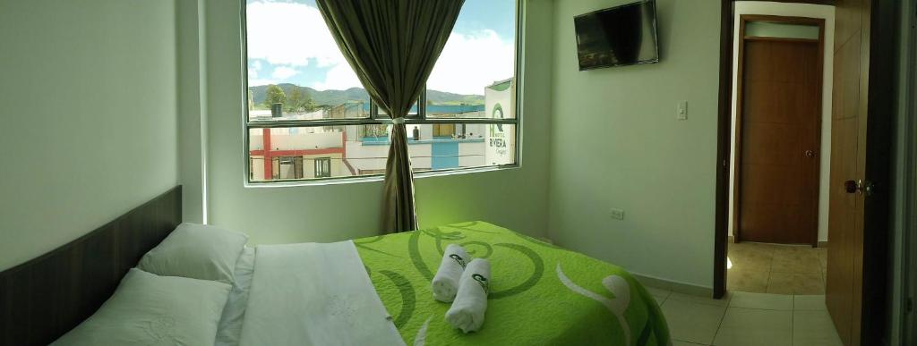 a bedroom with a bed with two stuffed animals on it at Hotel Riviera Confort in Pasto