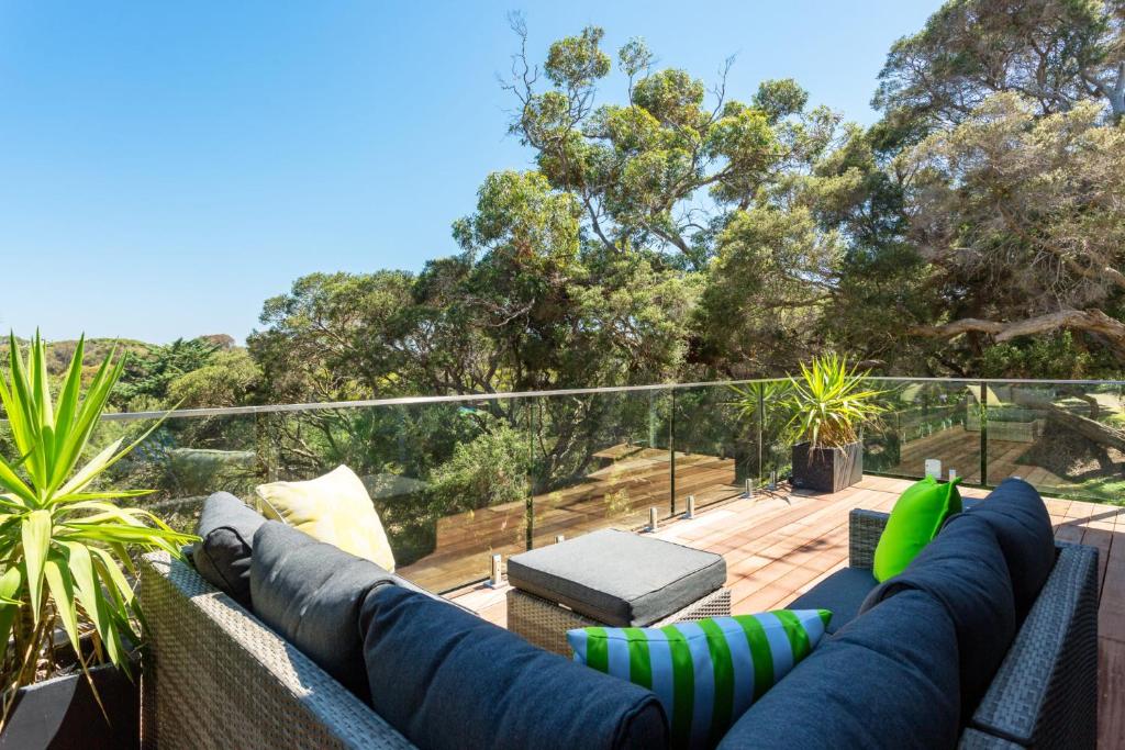 a patio with a couch and chairs on a deck at At Agnes Ave: coastal views in Blairgowrie