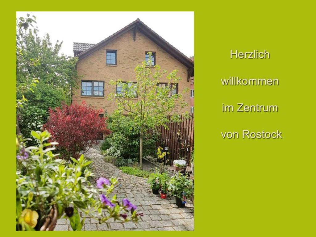 un jardín frente a una casa con flores en Ferienwohnung am Stadthafen _ Obje en Rostock