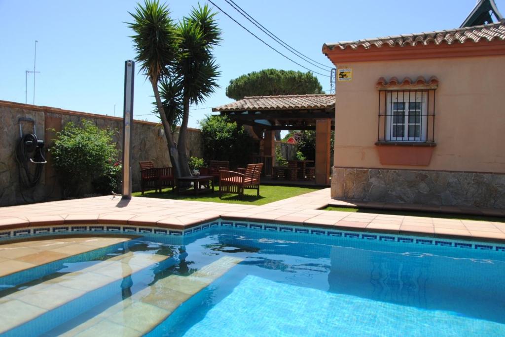een zwembad voor een huis bij Villa Solea in Chiclana de la Frontera