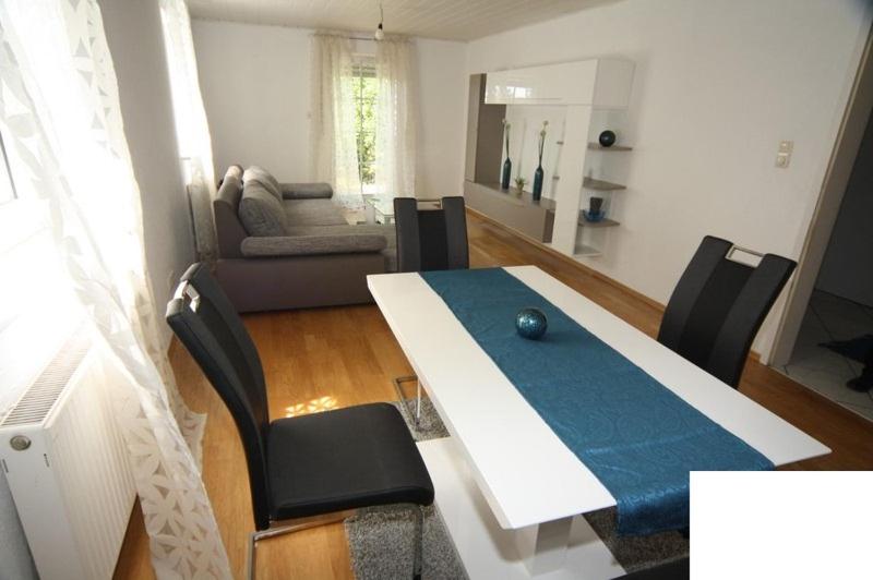ein Esszimmer mit einem Tisch und Stühlen sowie ein Wohnzimmer in der Unterkunft Obere Kellerstraße Haus 3 in Forchheim