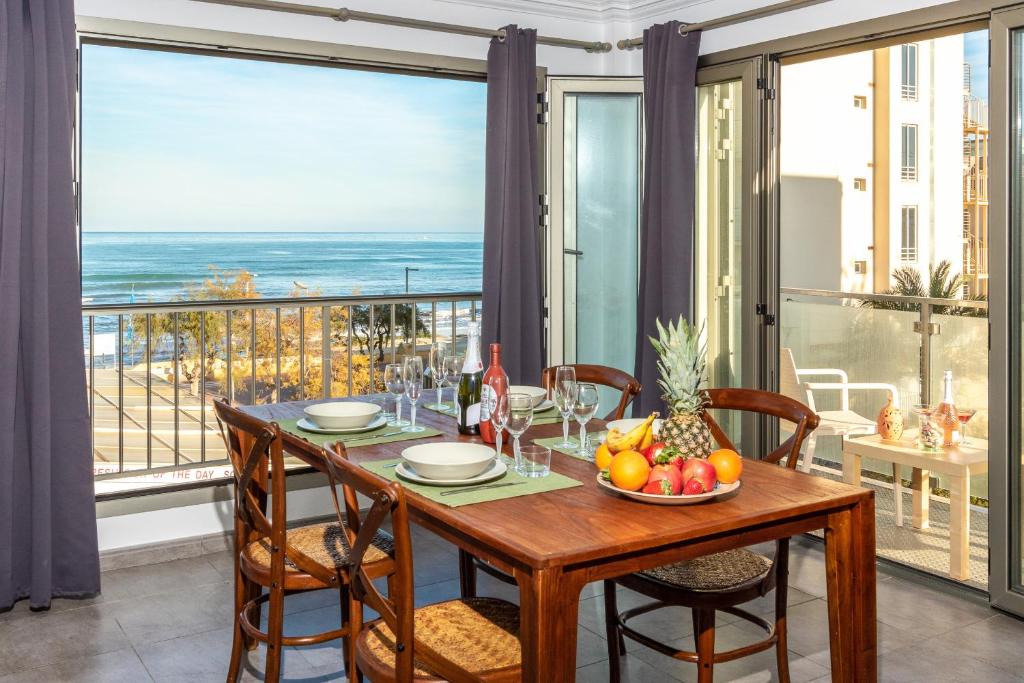 een eetkamer met een tafel en uitzicht op de oceaan bij Apartamento Castello Playa in Can Picafort