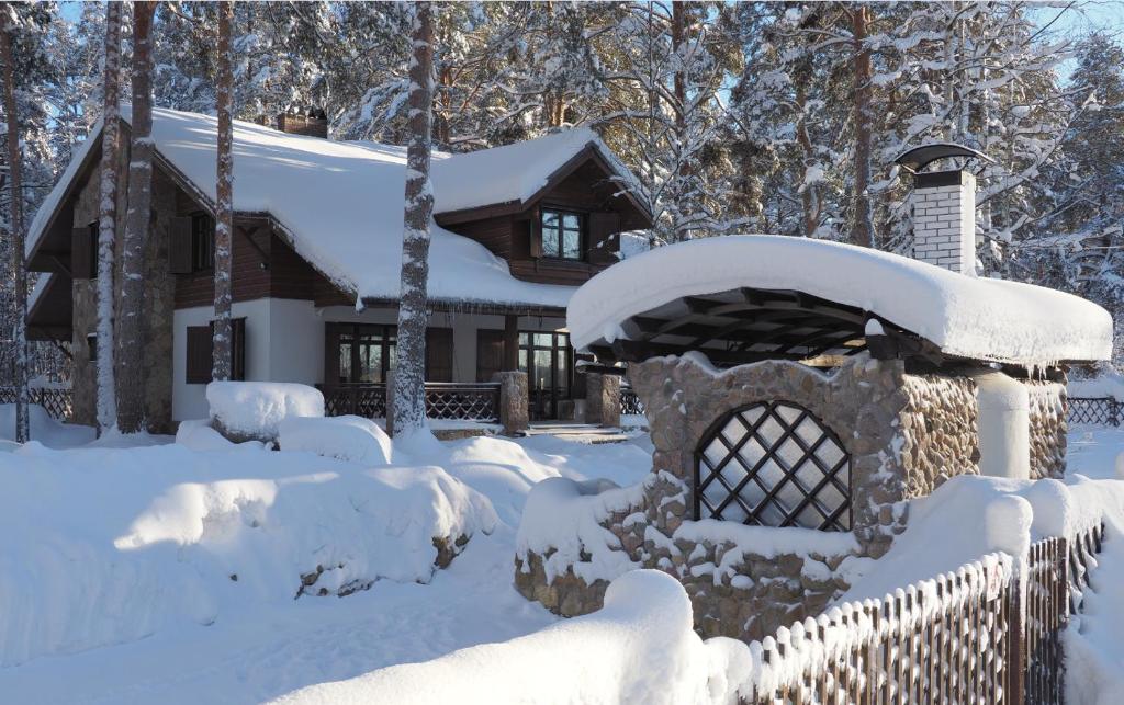 una casa cubierta de nieve con una valla en Chalet Ray Holiday Home, en Klevernoye