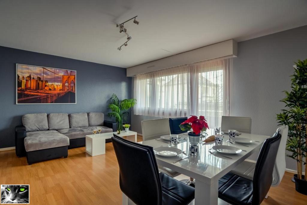 a living room with a table and a couch at Appartement Spacieux Schiltigheim in Schiltigheim