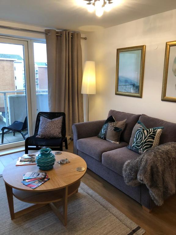 een woonkamer met een bank en een salontafel bij Hansen House Cardiff Apartment with Parking in Cardiff