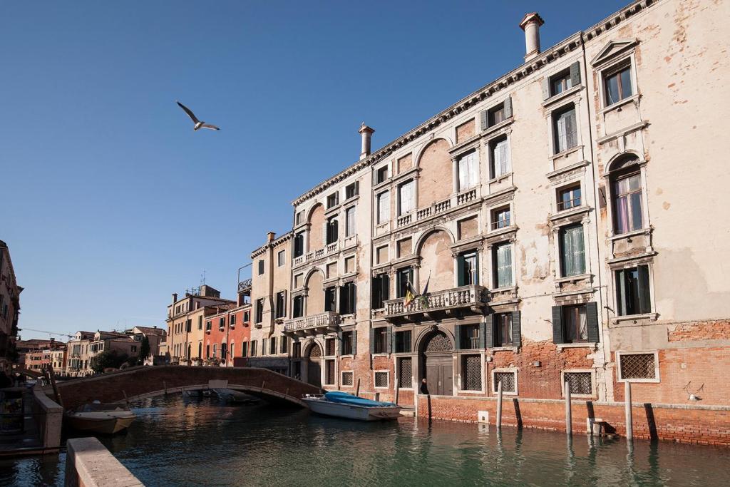 a bridge over a canal in a city with buildings at Appartamenti Palazzo Foscarini . in Venice