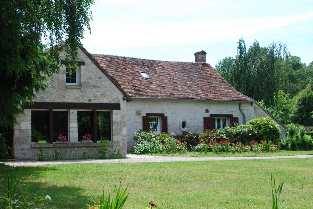 a house with a garden and flowers in the yard at La Petite Marguerite in Chitenay
