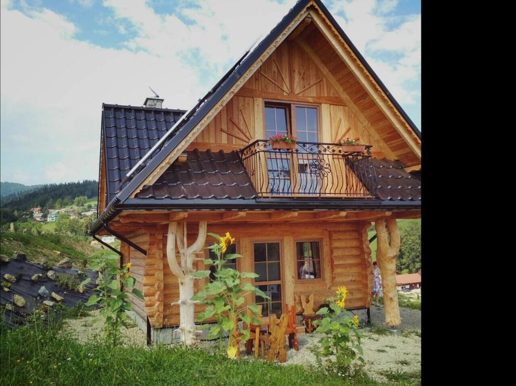 a log cabin with a balcony on top of it at Domek "Pod Lubaniem" in Grywałd
