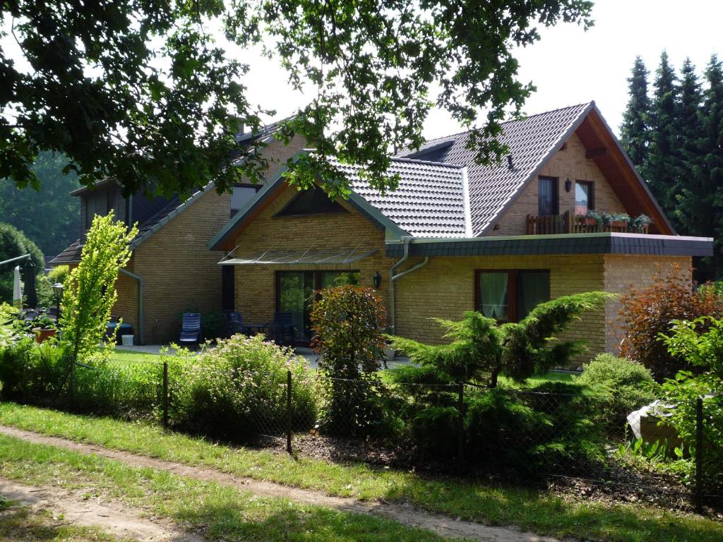 uma casa com um jardim em frente em Ullas Gästehaus em Munster im Heidekreis