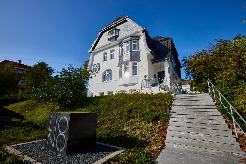 uma grande casa branca com escadas que levam até ela em LIONO BoutiqueHotel em Goslar