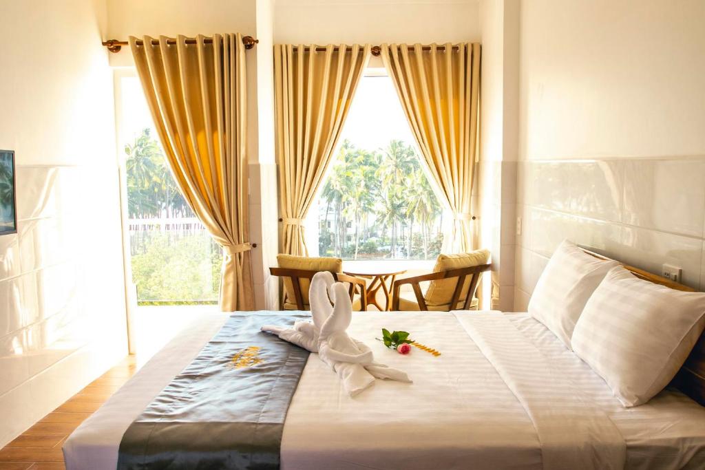 a bedroom with a large bed with flowers on it at Mui Ne Beach Hotel in Mui Ne