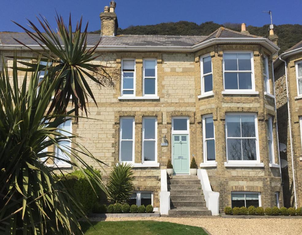 an old brick house with a blue door at Little Grosvenor in Ventnor