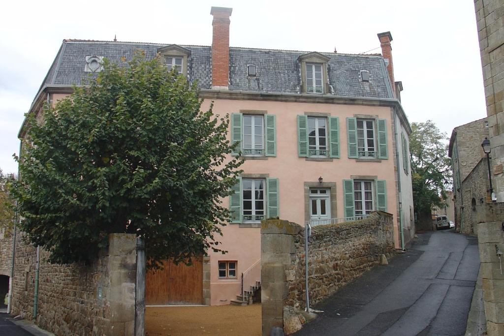 un vieux bâtiment avec un arbre en face dans l'établissement L Echarpe d Iris, à Montpeyroux