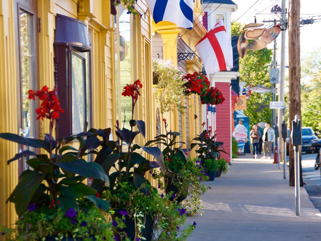 una calle con edificios con flores y una bandera en Rum Runner Inn, en Lunenburg