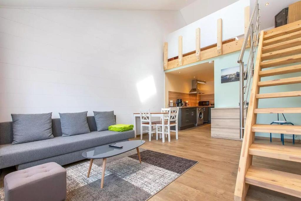 a living room with a couch and a table at Domaine des Ecuries - Appartements meublés à Talloires in Talloires