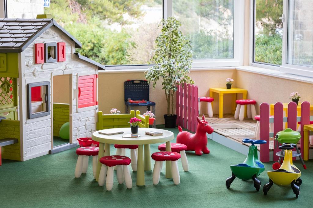 a play room with a table and chairs and a doll house at Sun Gardens Dubrovnik in Dubrovnik