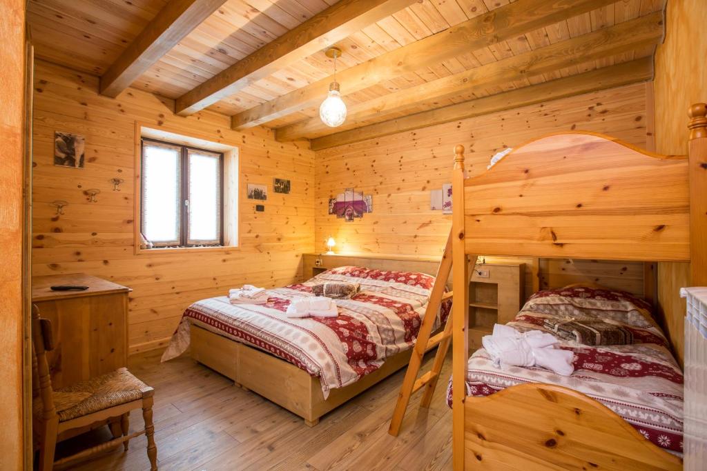 1 dormitorio con 2 camas en una cabaña de madera en Alloggio del contadino en Sondrio